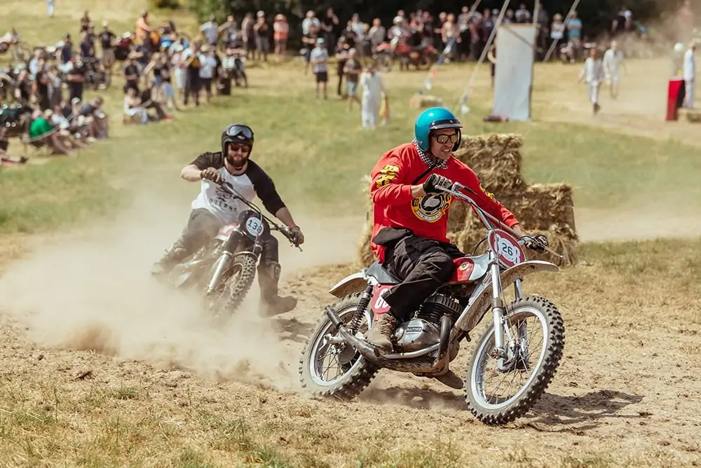 Two motorcyclists racing around a dirt track