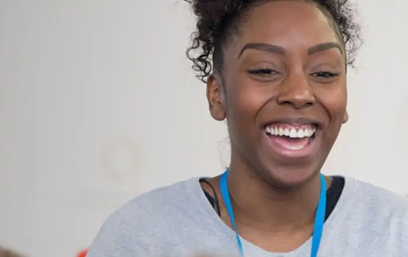 A laughing woman wearing a lanyard