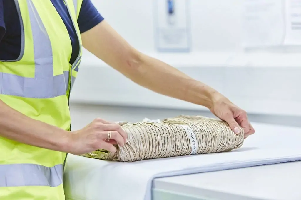 Gift wrapping fulfilment service - a woman carefully wraps an item