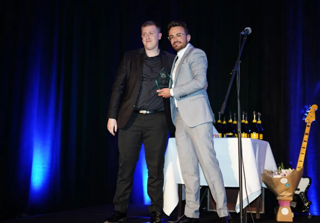 2 employees accepting an award on stage